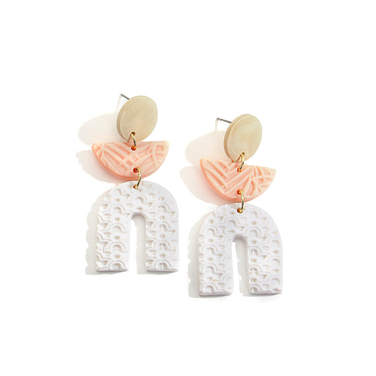 Boucles d'oreilles en argile polymère de Petites Aventures, teintées de blanc et rose poudré, faites à la main avec un motif géométrique