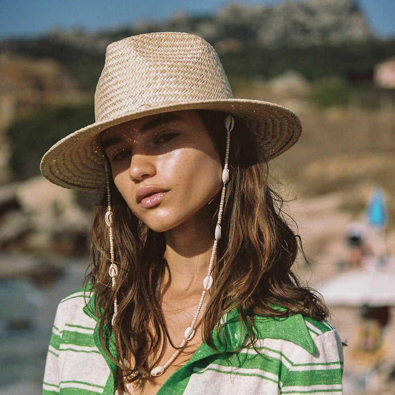 Femme a la plage avec le Chapeau de plage Accessoire d'été Femme Paille tissée Perlé Coquillages de mer panama Vacances Nouvelle collection 2023 Tendance de mode collection Summer chic de la boutique Petites Aventures